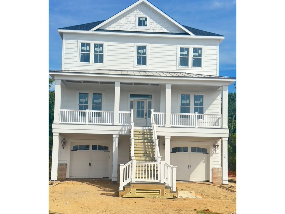 Finished exterior with porch, railings, and carriage garage doors