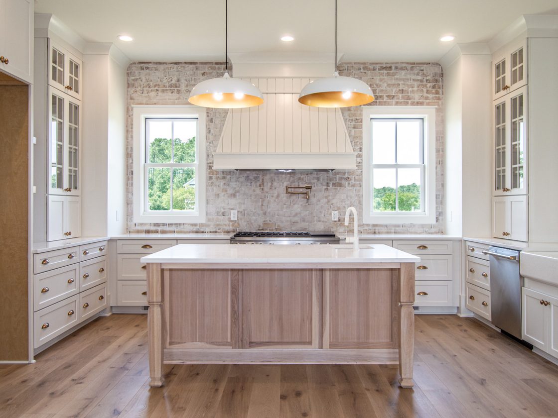 Kitchen with white oak island and brick backsplash